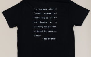 Back view of She Brews black t-shirt with Paul of Tarsus quote in white text