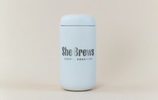 she-brews-coffee-canister-white-unsung-roasters. White She Brews Coffee Roasters airtight canister with minimalist branding