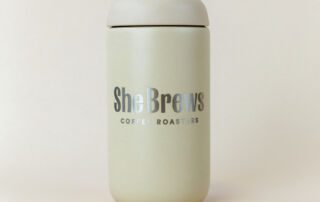 she-brews-coffee-roasters-canister-sand-dune-front-unsung-roasters. Sand Dune color She Brews Coffee Roasters canister with logo