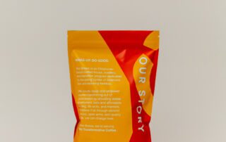 she-brews-peacemaker-coffee-back-12oz-unsung-roasters. Back of the 12oz She Brews Peacemaker coffee bag highlighting the company’s mission and social impact