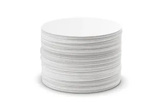 Stack of round AeroPress paper coffee filters on a white background.