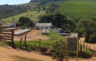 kith-kin-brazil-coffee-farm-cerrado-terrain-natural-process-unsung-roasters. Coffee farm in Brazil’s Cerrado region with drying beds and rolling green hills.