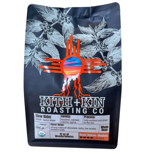 Kith + Kin Slow Rider Swiss Water Decaf coffee bag with silver and orange highlights.