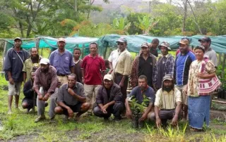kith-kin-papua-new-guinea-coffee-farmers-cooperative-unsung-roasters. Group of Papua New Guinea coffee farmers from a local cooperative standing together on a lush farm.